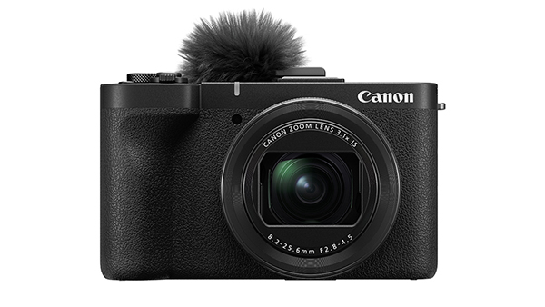 This is an image of the Canon PowerShot V1 viewed from the front with a windscreen accessory on top of the camera on a white background.