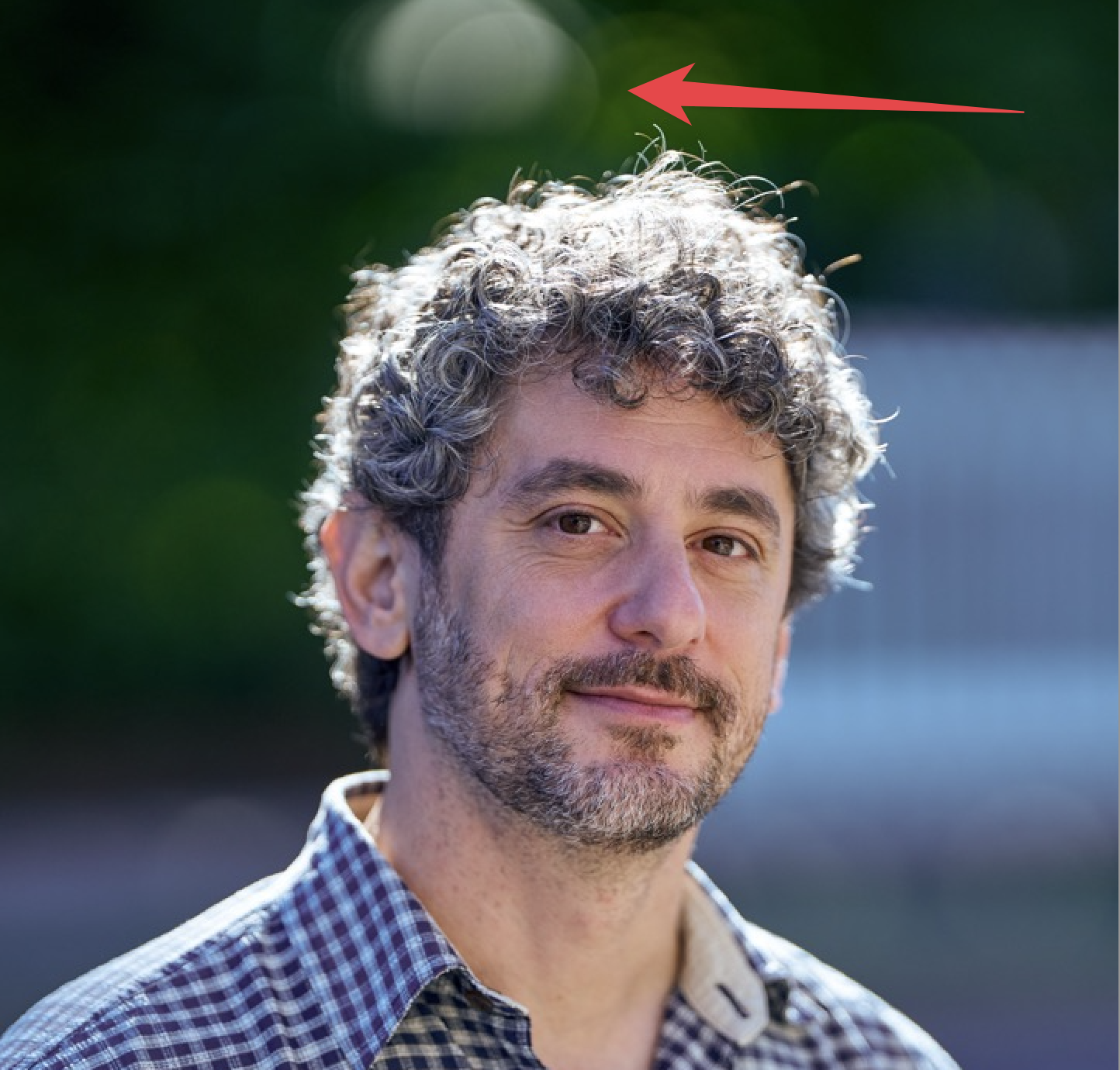 An illustrative photo of a man standing in the foreground, an arrow points to a problematic part of the image. 