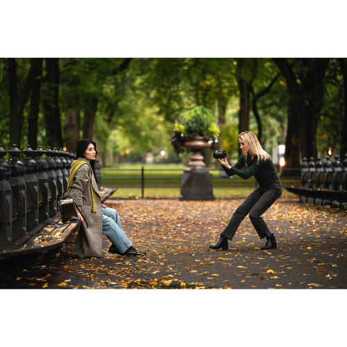 A woman taking a picture using a Nikon Z50 II of another woman in a park
