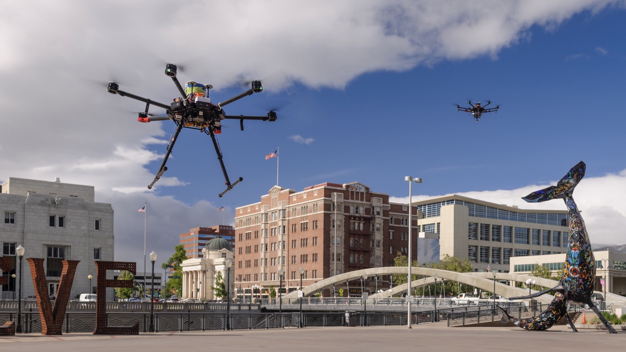 Drones hover above a bridge and buildings next to a waterway