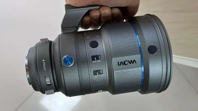 A person holding the Venus Optics Laowa AF 200mm f/2