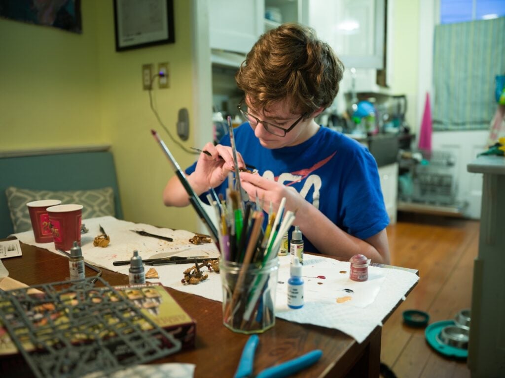 A boy painting miniatures