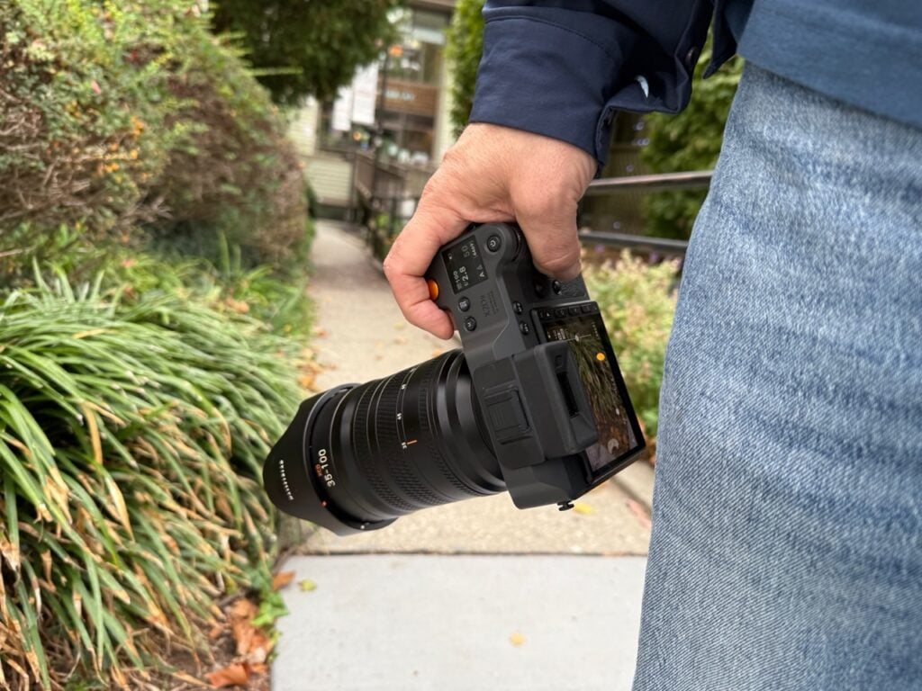 Holding an X1D II 100C with the lcd screen showing the image