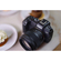 A canon camera and the 45mm f/1.2 STM lens on a table in a caffee. A plate of food is beside the camera.