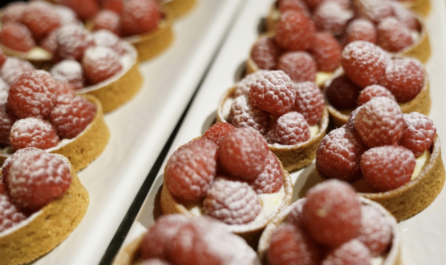 Pastery cups with raspberries dusted in sugar. 