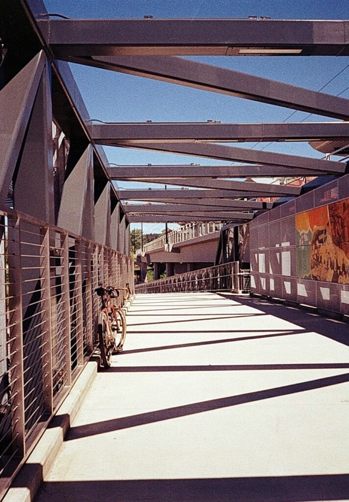 A bicycle against the fence of a pedestritan bridge.